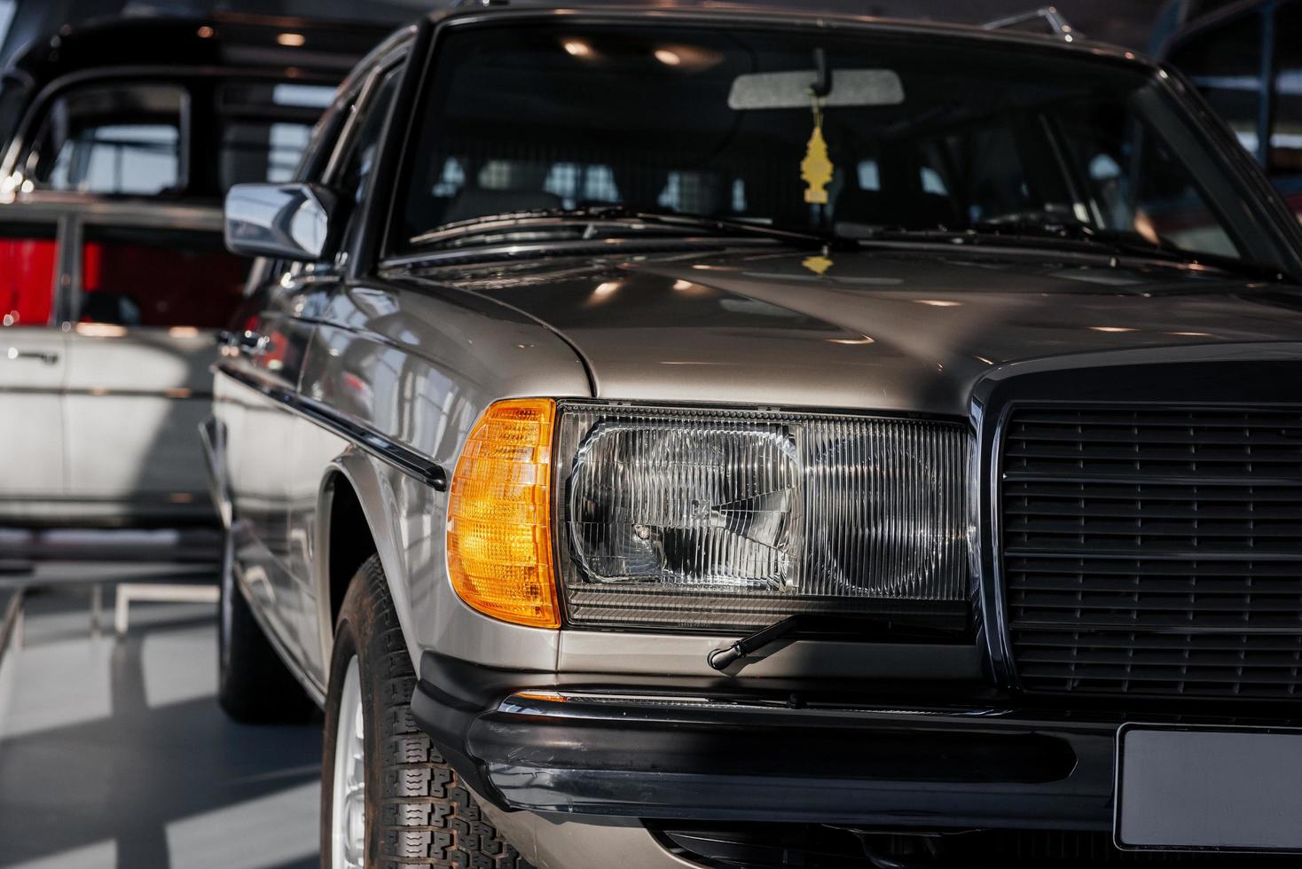 vue de face de la belle vieille voiture de couleur argent garée sur le carreau blanc photo