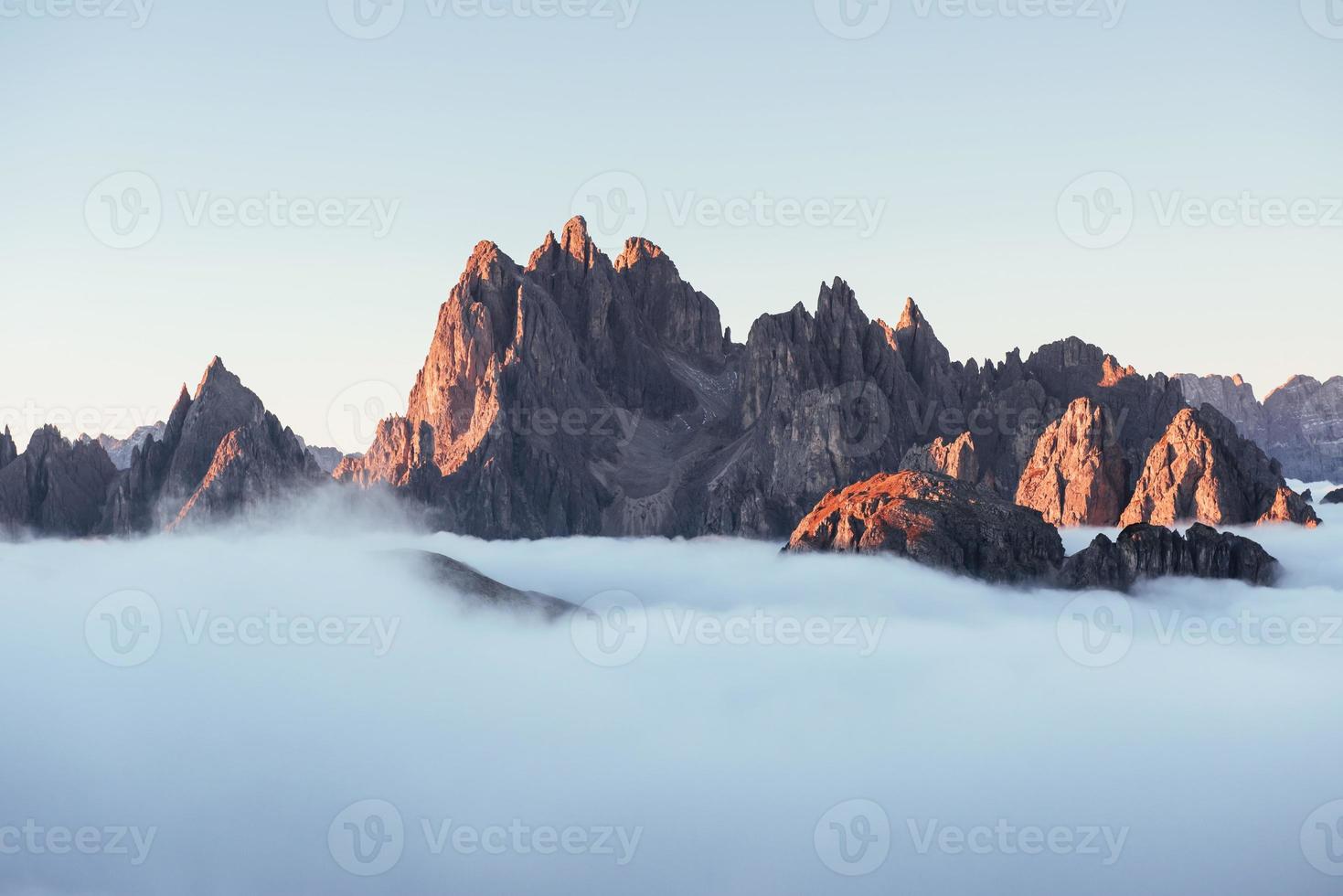 des rochers dormant sous une brume englobante. les sommets des montagnes étouffent d'un épais brouillard. photo incroyable prend