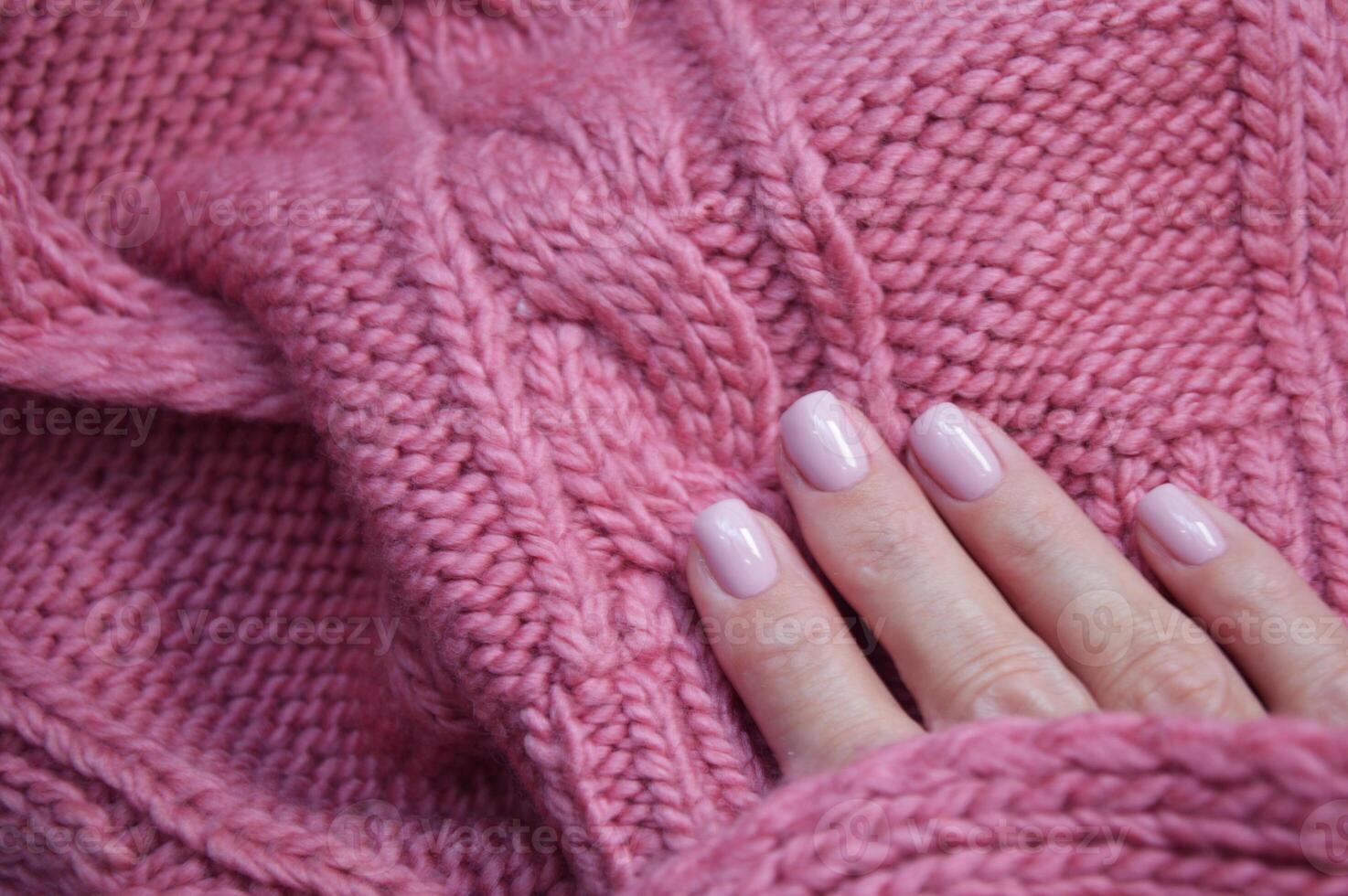 femelle mains avec magnifique ongles dans une chaud rose tricoté chandail. hiver s'orienter, professionnel manucure avec gel polonais, gomme laque. photo