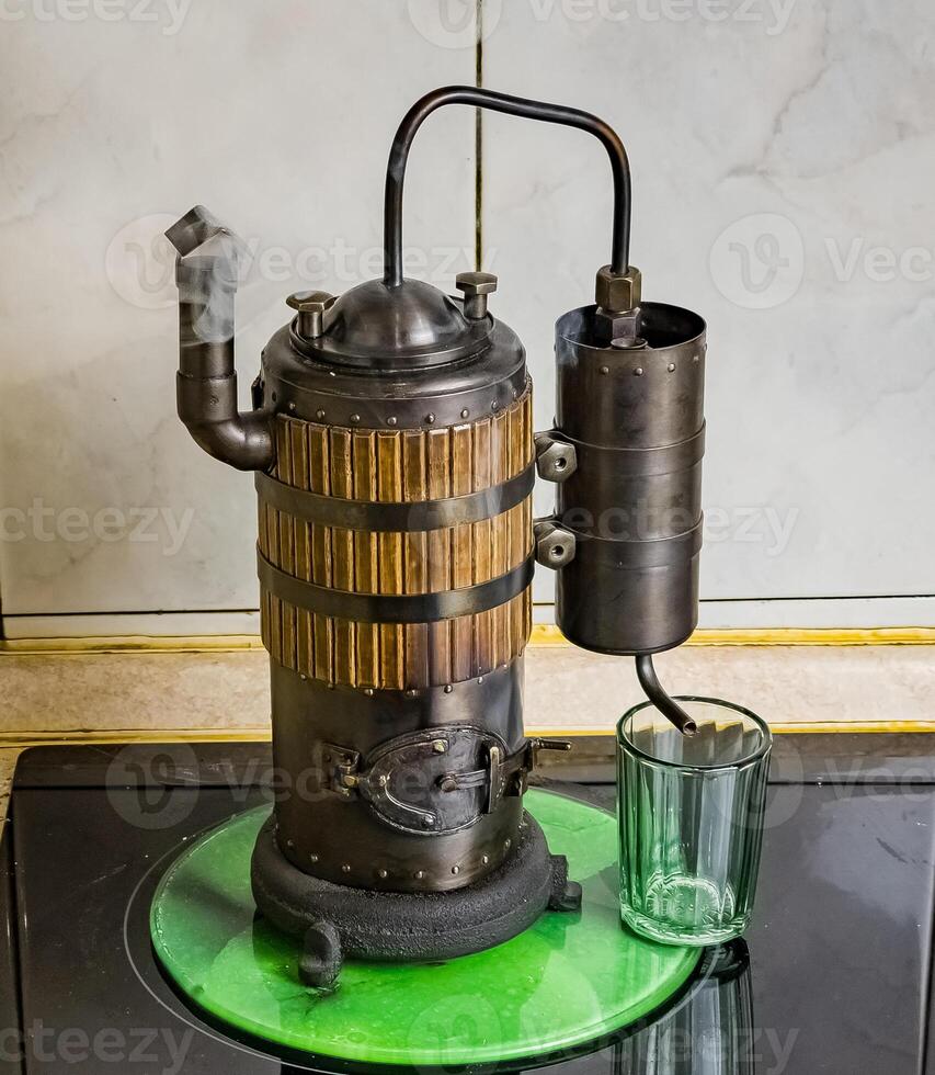 le processus de distiller du vin à une mini distillerie en utilisant bois. le volume 400 ml. photo