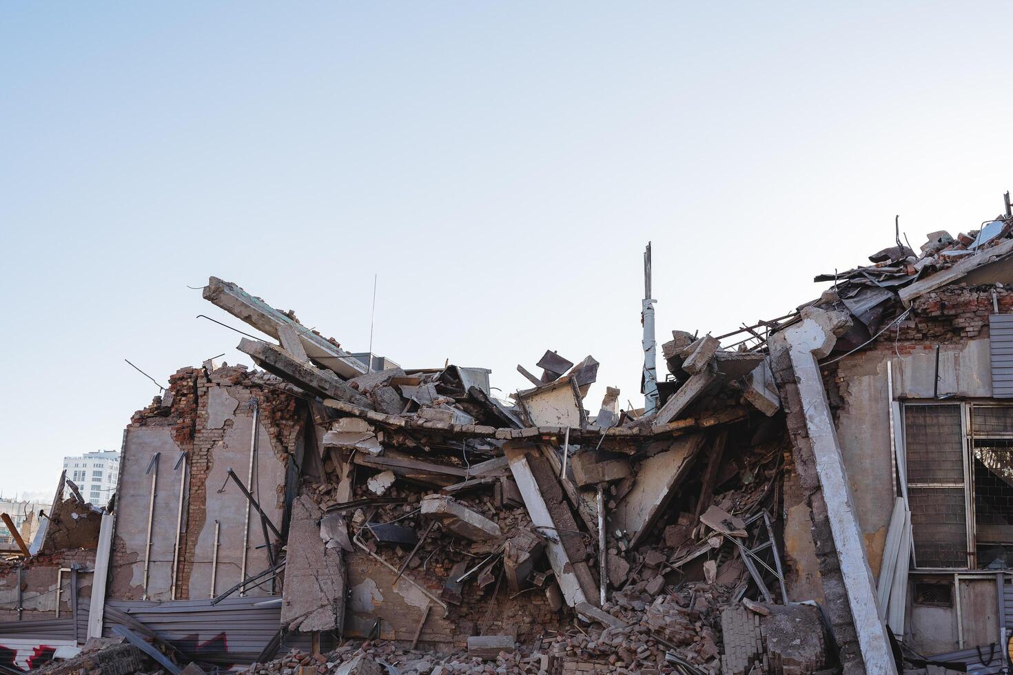 explosion de un appartement bâtiment, débris de une béton bâtiment après une coquille frapper. tremblement de terre dans le ville, restes de bâtiment autorisation des murs. le conséquences de le catastrophe. photo