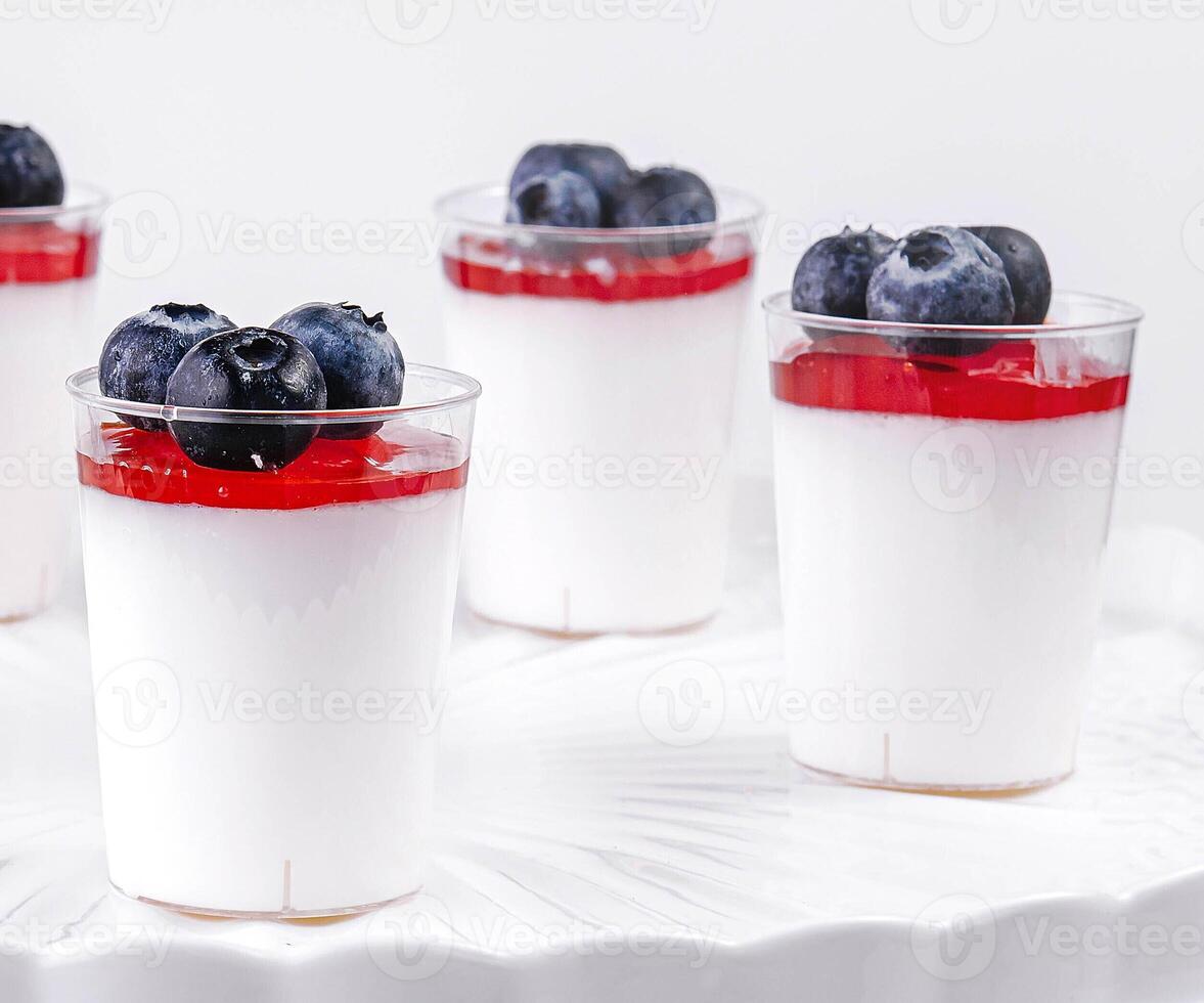 verre tasse de yaourt avec myrtilles sur blanc table photo