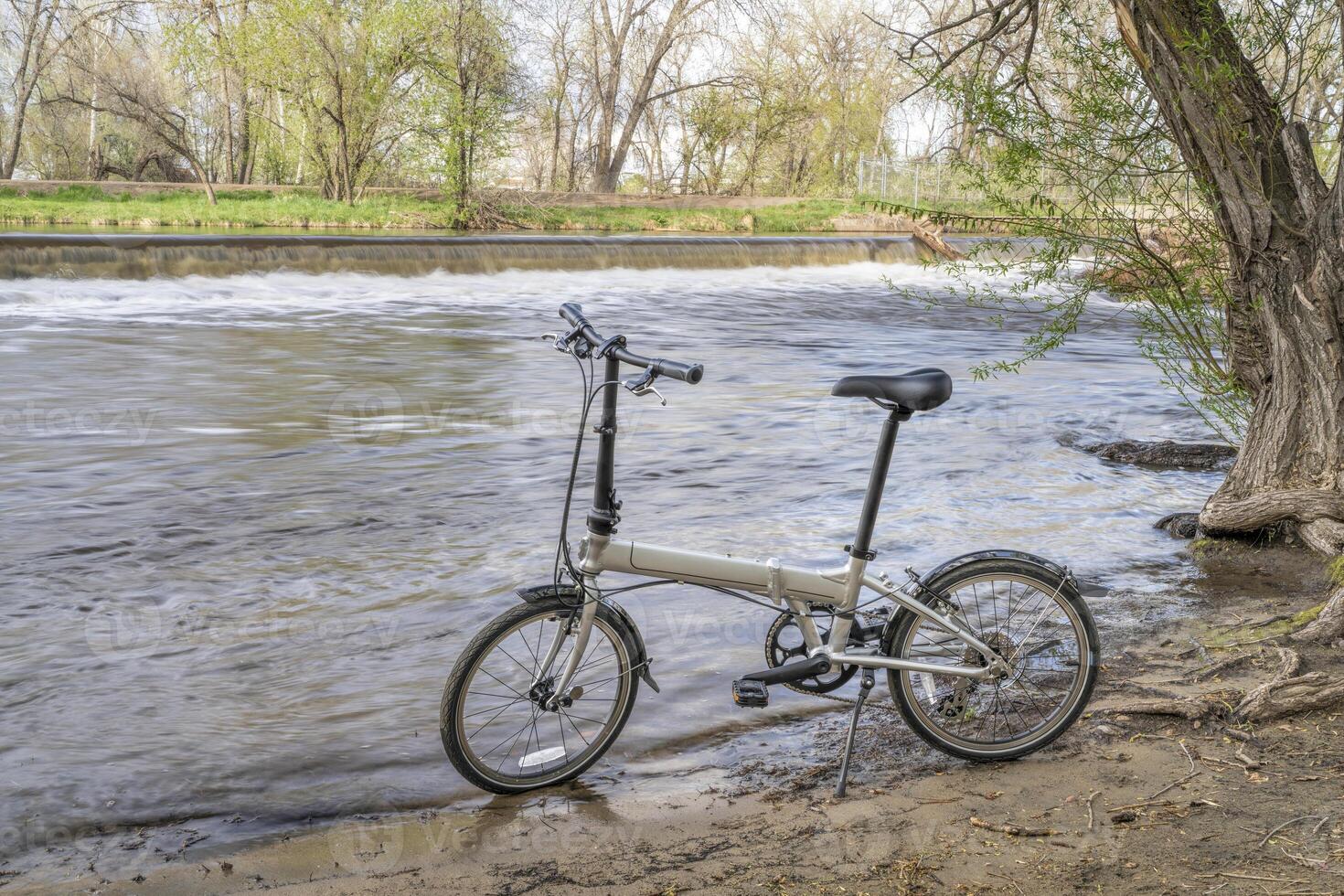 poids léger pliant bicyclette sur une rive de le poudre rivière dans fort collins, Colorado, printemps paysage photo