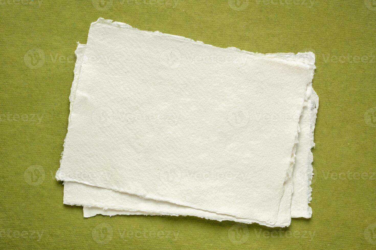 petit feuille de Vide blanc khadi papier contre vert chiffon papier photo