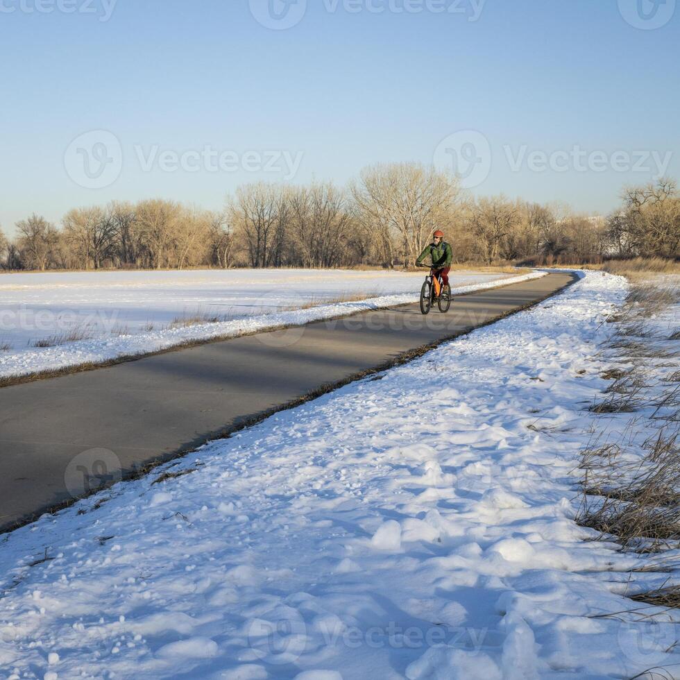 Sénior Masculin cycliste sur une bicyclette Piste dans hiver paysage - poudre rivière Piste dans nord Colorado, Cyclisme, des loisirs et faire la navette concept photo