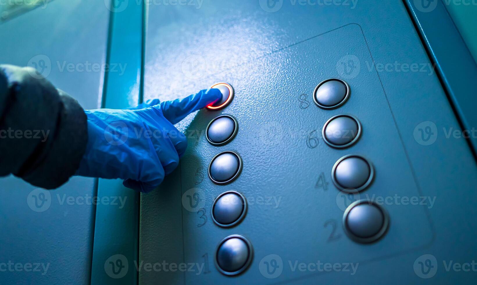 coronavirus épidémie. main portant caoutchouc bleu gant pressage ascenseur boutons. hygiène concept, les bactéries et virus la prévention. soi protection. photo