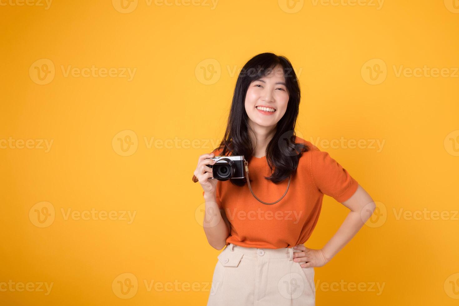 Jeune femme avec une caméra isolé sur Jaune Contexte capturer souvenirs sur une amusement vacances voyage. aventure et la photographie concept. photo