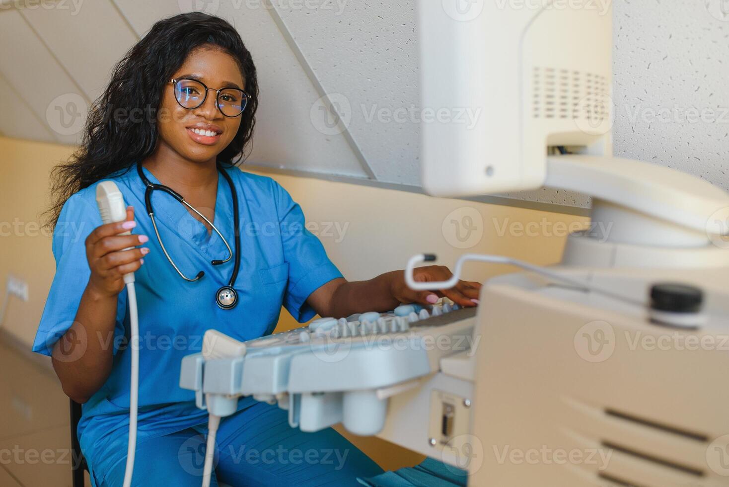 Jeune de bonne humeur africain femme opérateur de un ultrason balayage machine en cours d'analyse Diagnostique résultats de patient. Jeune souriant africain médecin travail sur une moderne ultrason équipement. photo