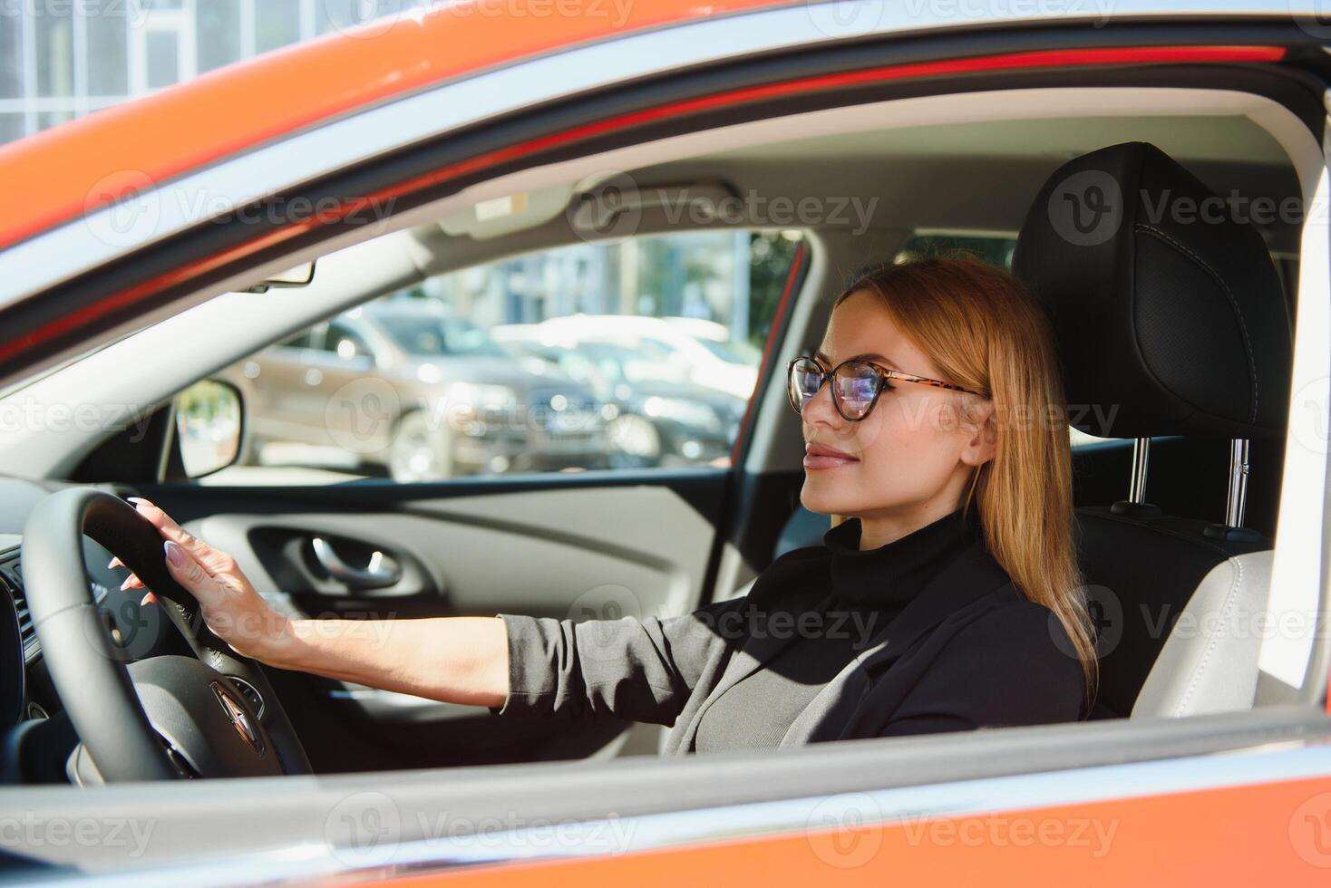 magnifique mature femme dans affaires costume conduite une voiture à bureau. femme d'affaires conduire une voiture dans ville. photo