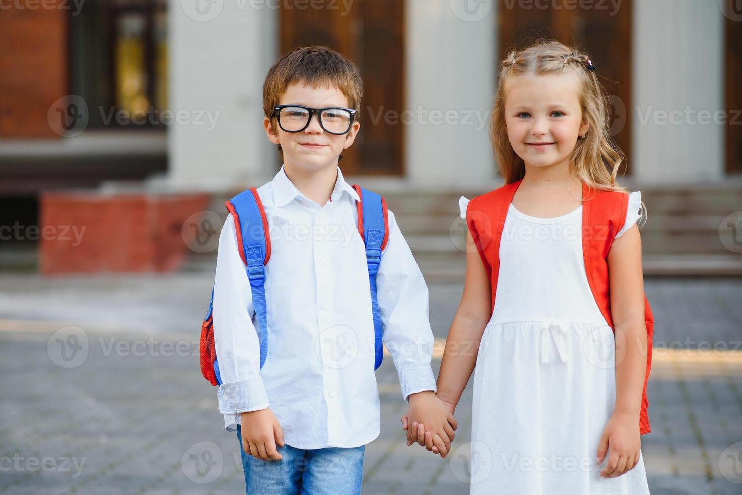 content les enfants aller retour à école. élève de primaire école aller étude avec sac à dos en plein air. des gamins aller main dans main. début de cours. premier journée de automne. garçon et fille de élémentaire étudiant. photo