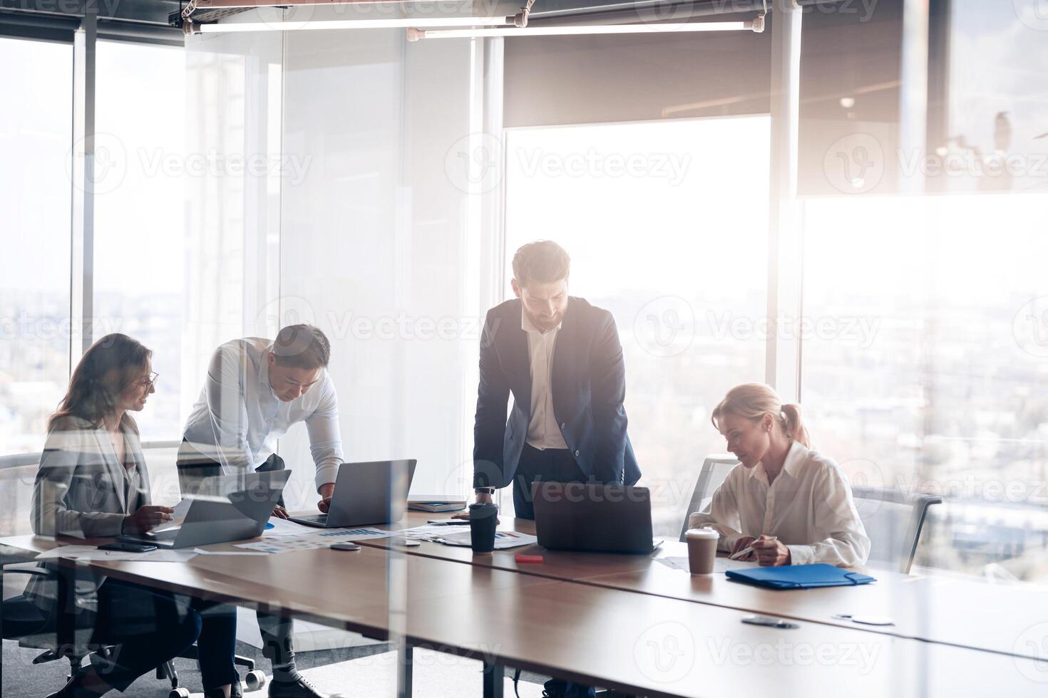 équipe de Jeune les hommes d'affaires travail et communicant ensemble dans Bureau avec panoramique les fenêtres photo