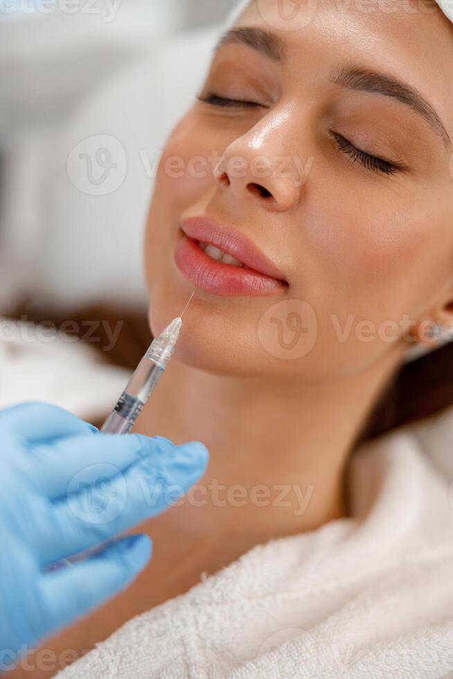 fermer de Jeune femme avoir rajeunissant injections dans lèvres à beauté salon photo