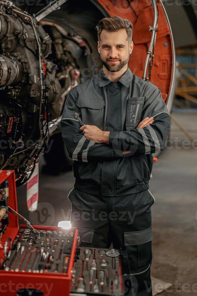 Masculin avion mécanicien permanent près outil boîte dans hangar photo