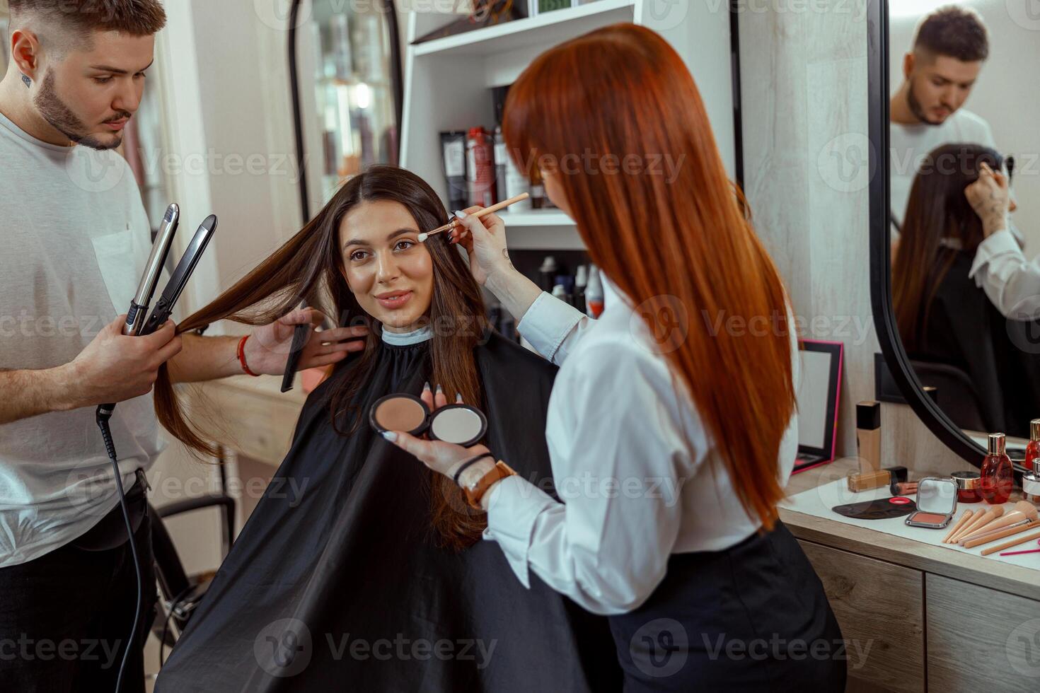 professionnel maquillage artiste et coiffeur en train de préparer femelle client dans beauté salon photo