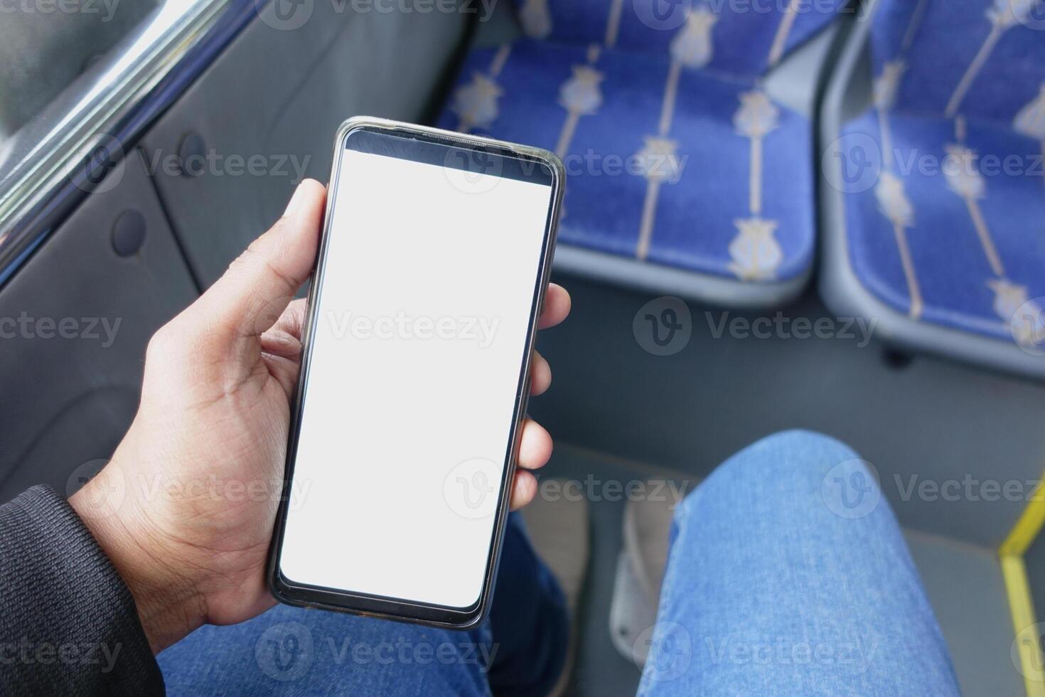 passager séance dans une autobus en utilisant le sien téléphone. photo