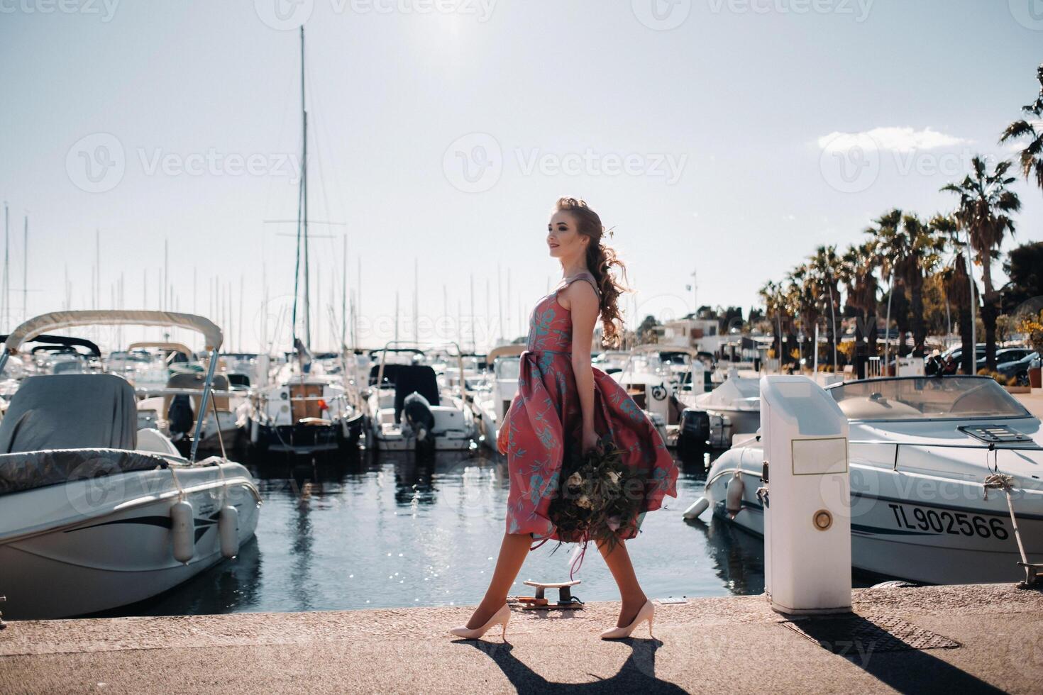 Jeune modèle fille dans une magnifique robe avec une bouquet de fleurs sur le plage dans France. fille avec fleurs dans printemps Provence sur le français riviera photo