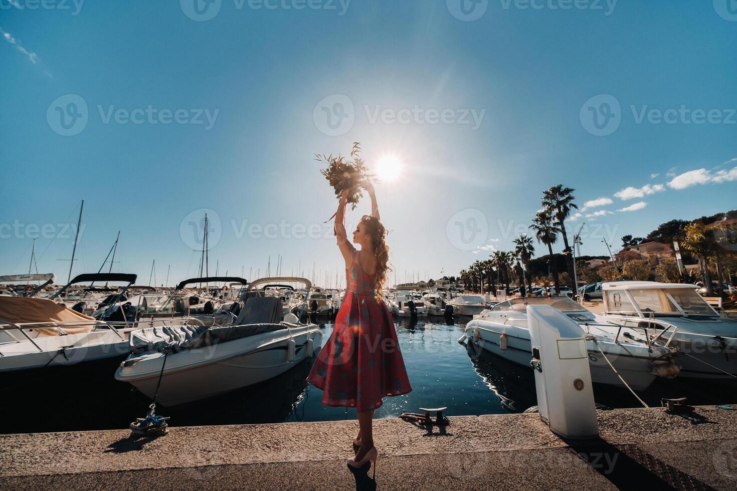 Jeune modèle fille dans une magnifique robe avec une bouquet de fleurs sur le plage dans France. fille avec fleurs dans printemps Provence sur le français riviera photo