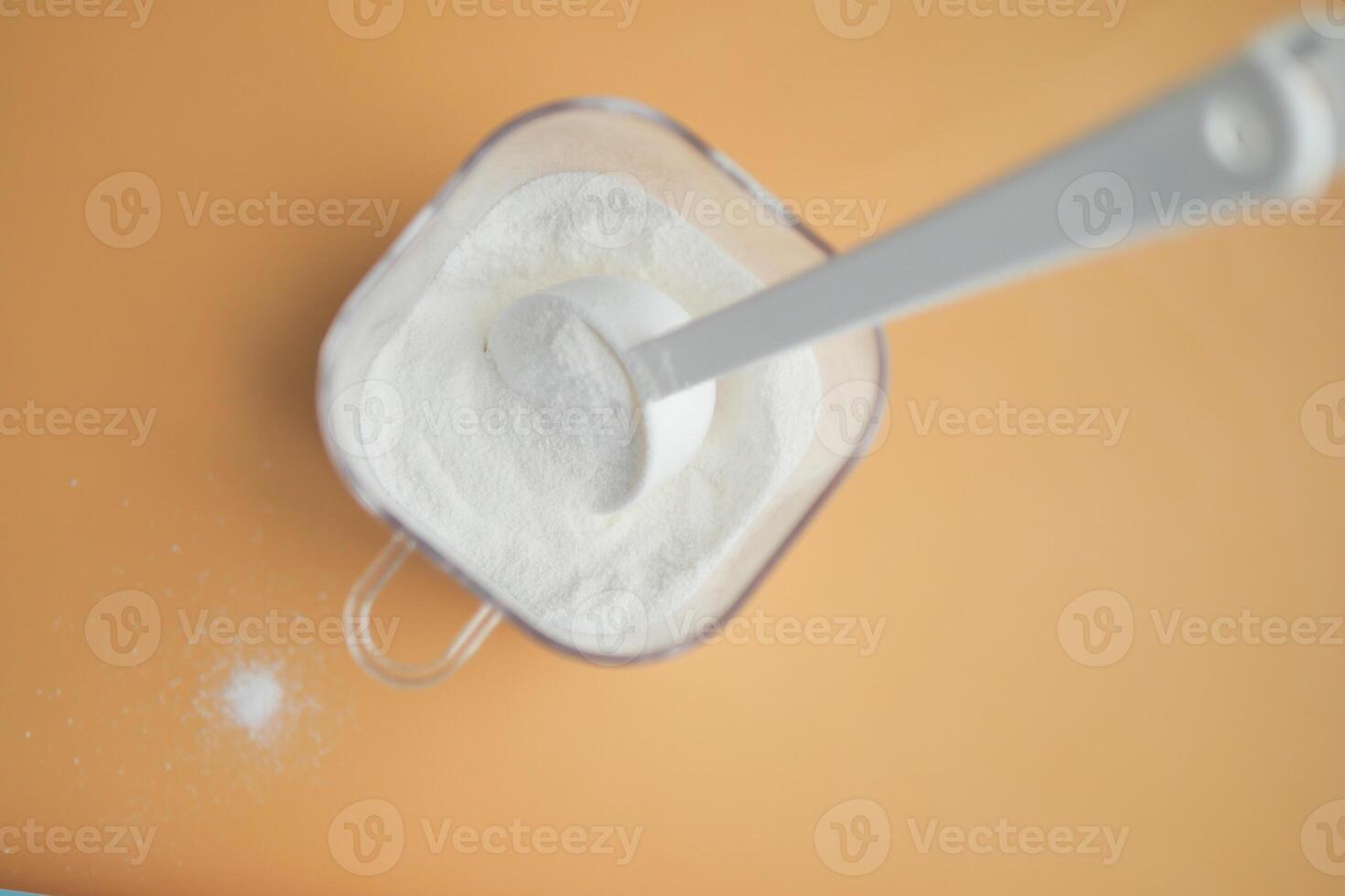 gros plan de lait en poudre pour bébé et cuillère sur fond de tuile. photo