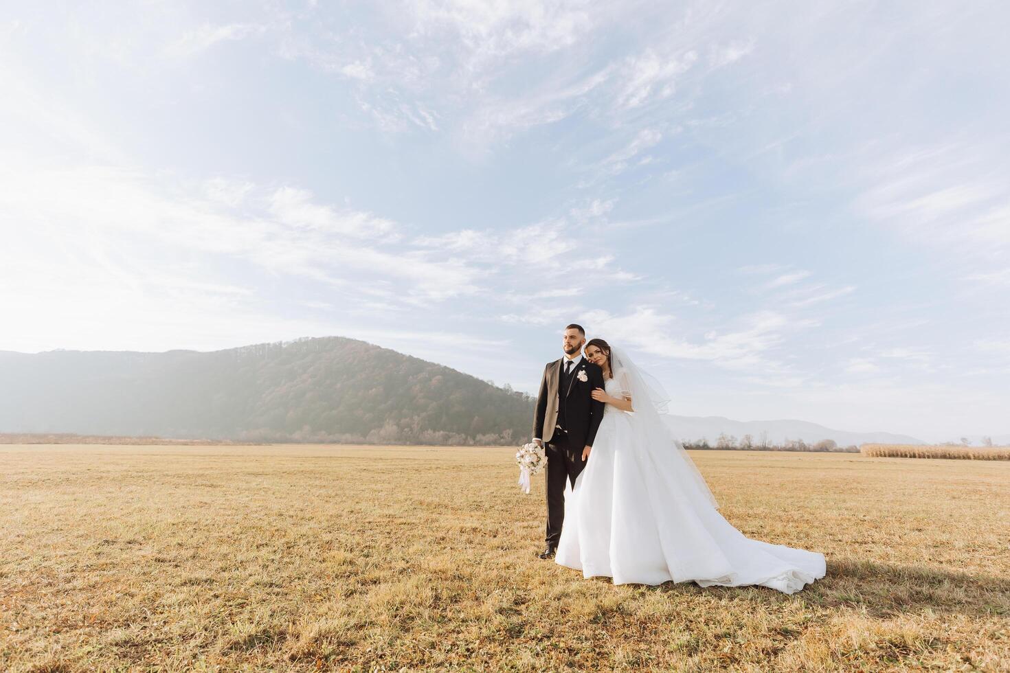 mariage couple sur une marcher dans le l'automne parc. le la mariée dans une magnifique blanc robe. l'amour et relation concept. jeune marié et la mariée dans la nature en plein air photo