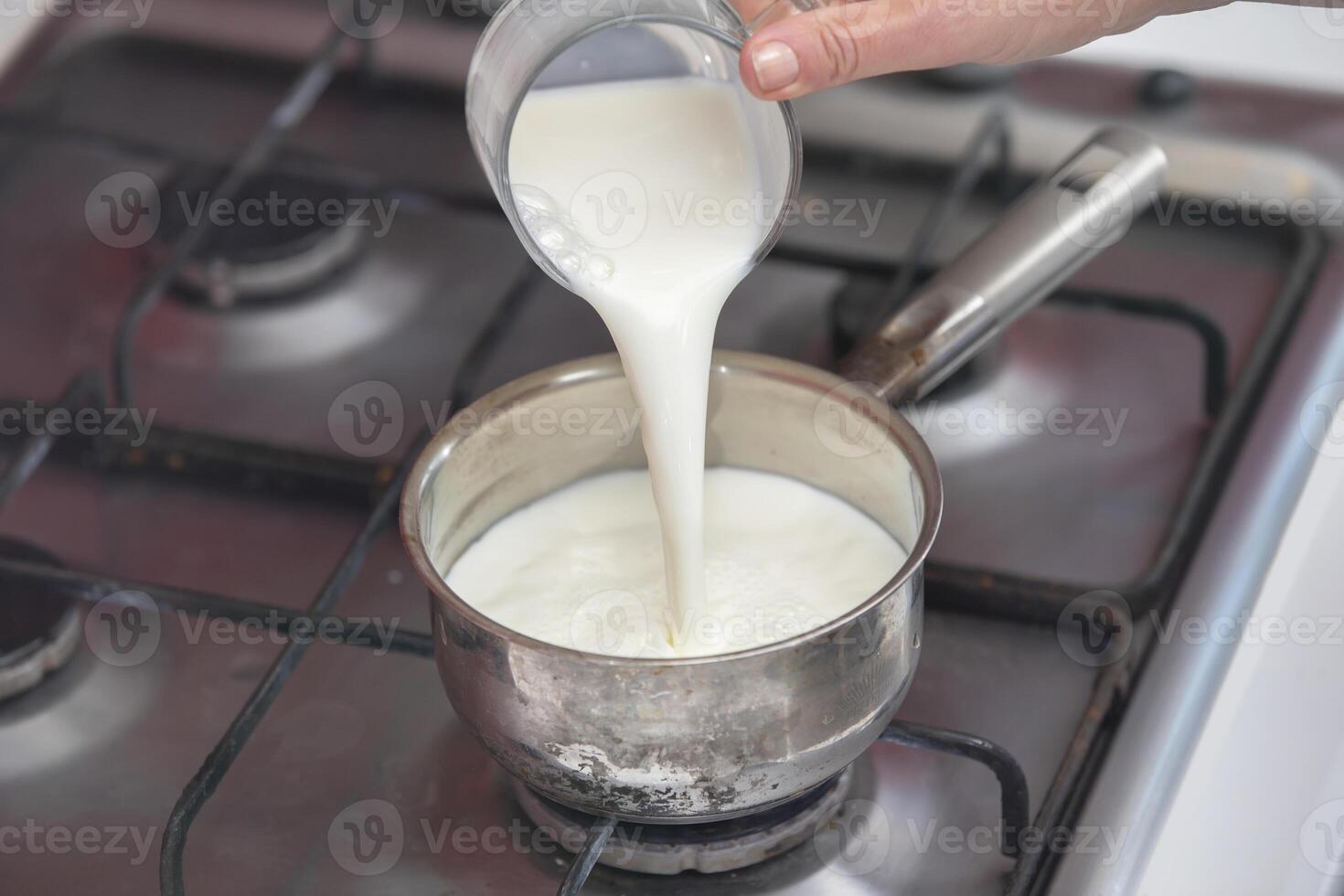 ébullition Lait dans une petit casserole sur le poêle. préparer Lait bouillie. photo