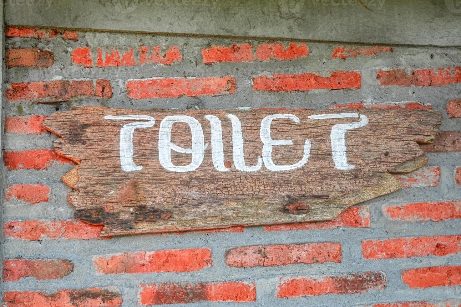 une en bois signe cette dit toilette est attaché à une brique mur photo