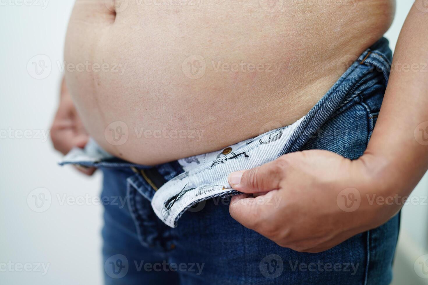 femme asiatique montre gros ventre grande taille surpoids et obésité au bureau. photo