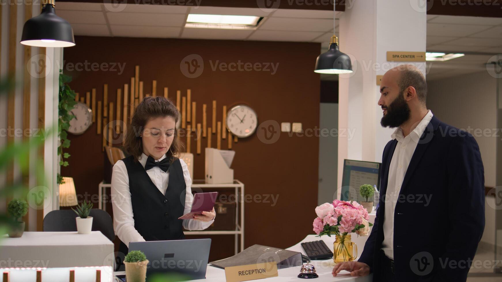 blanc collier ouvrier donne id papiers dans lobby, en train de préparer pour enregistrement après longue affaires vol. de face bureau employé révision passeport crédits à réception, génial service. photo