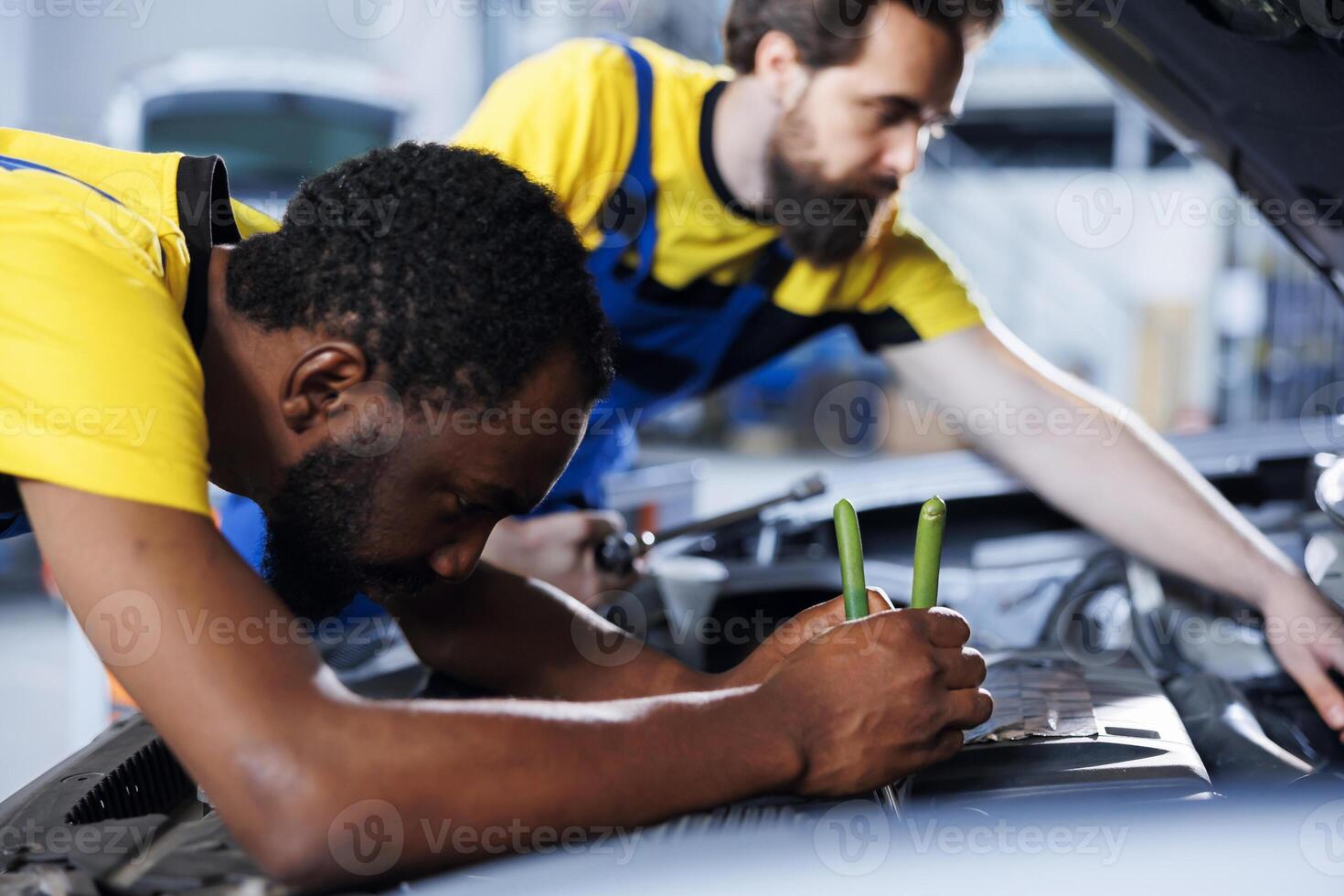 dépanneur et collaborateur collaborer sur entretien cassé véhicule, vérification pour défectueux moteur. agréé mécanique dans auto réparation magasin travail ensemble sur fixation voiture, discuter meilleur les options photo