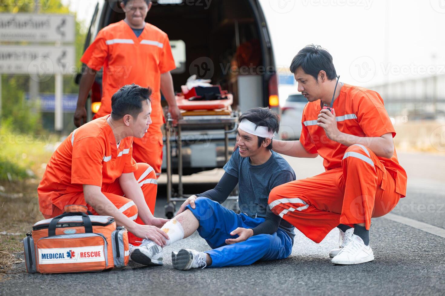 le paramédical est assistant un blessé homme dans un urgence situation sur le route. photo