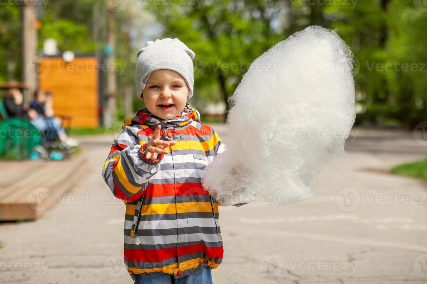 enfant garçon dans un amusement parc mange coton bonbons photo