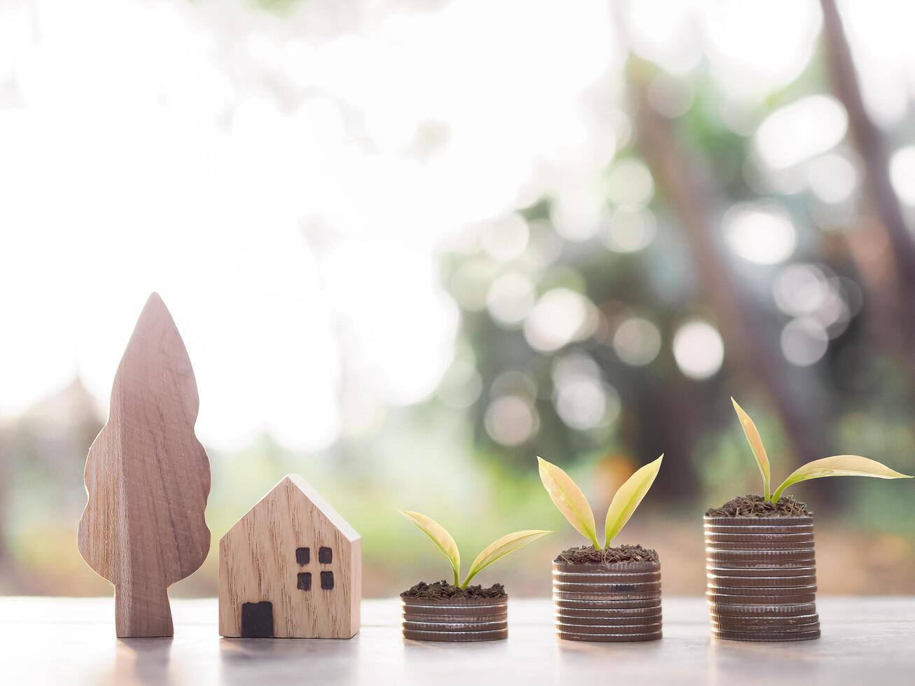 miniature maison et les plantes croissance en haut sur empiler de pièces de monnaie. le concept de économie argent pour loger, propriété investissement, maison hypothèque, réel domaine. photo