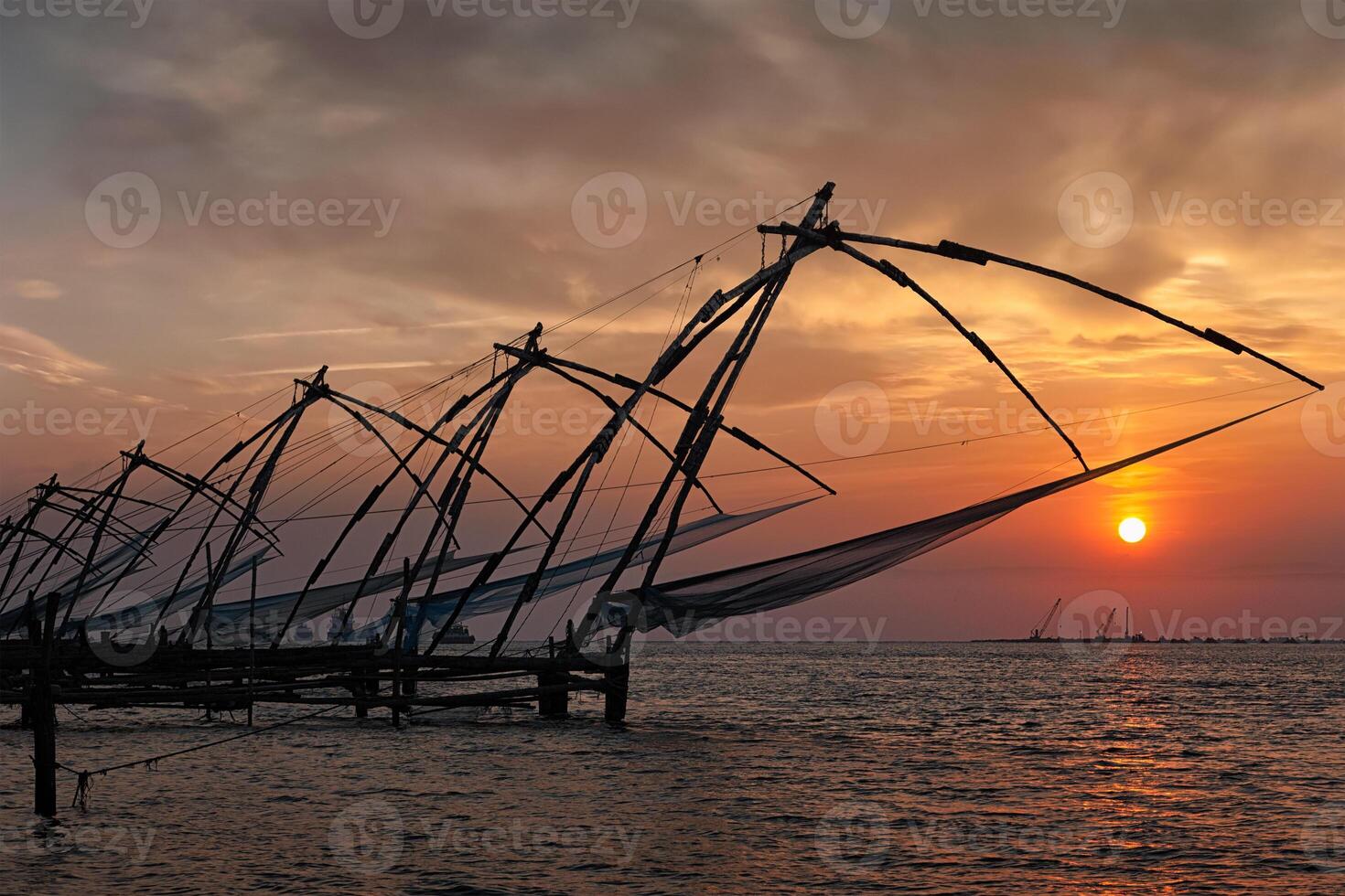 chinois filets de pêche sur le coucher du soleil. Kochi, Kerala, Inde photo