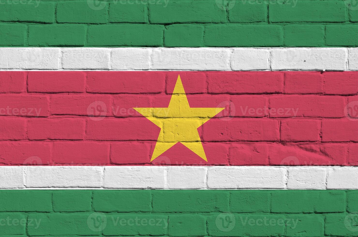 suriname drapeau représenté dans peindre couleurs sur vieux brique mur. texturé bannière sur gros brique mur maçonnerie Contexte photo