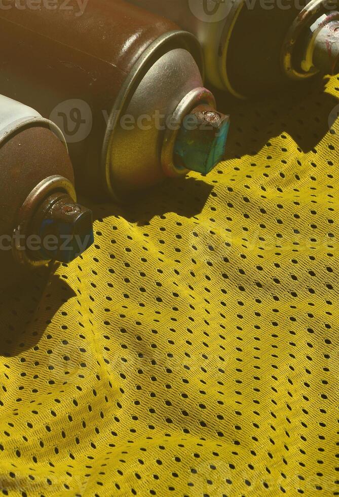 plusieurs pulvérisateurs de peinture en aérosol usagés se trouvent sur la chemise de sport d'un joueur de basket-ball en tissu polyester. le concept d'art de rue pour les jeunes, de sports actifs et de style de vie mouvementé photo