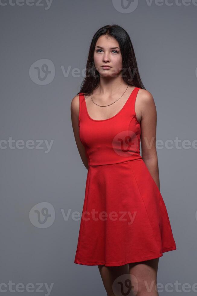 studio portrait de une Jeune magnifique fille dans une rouge robe 1 photo