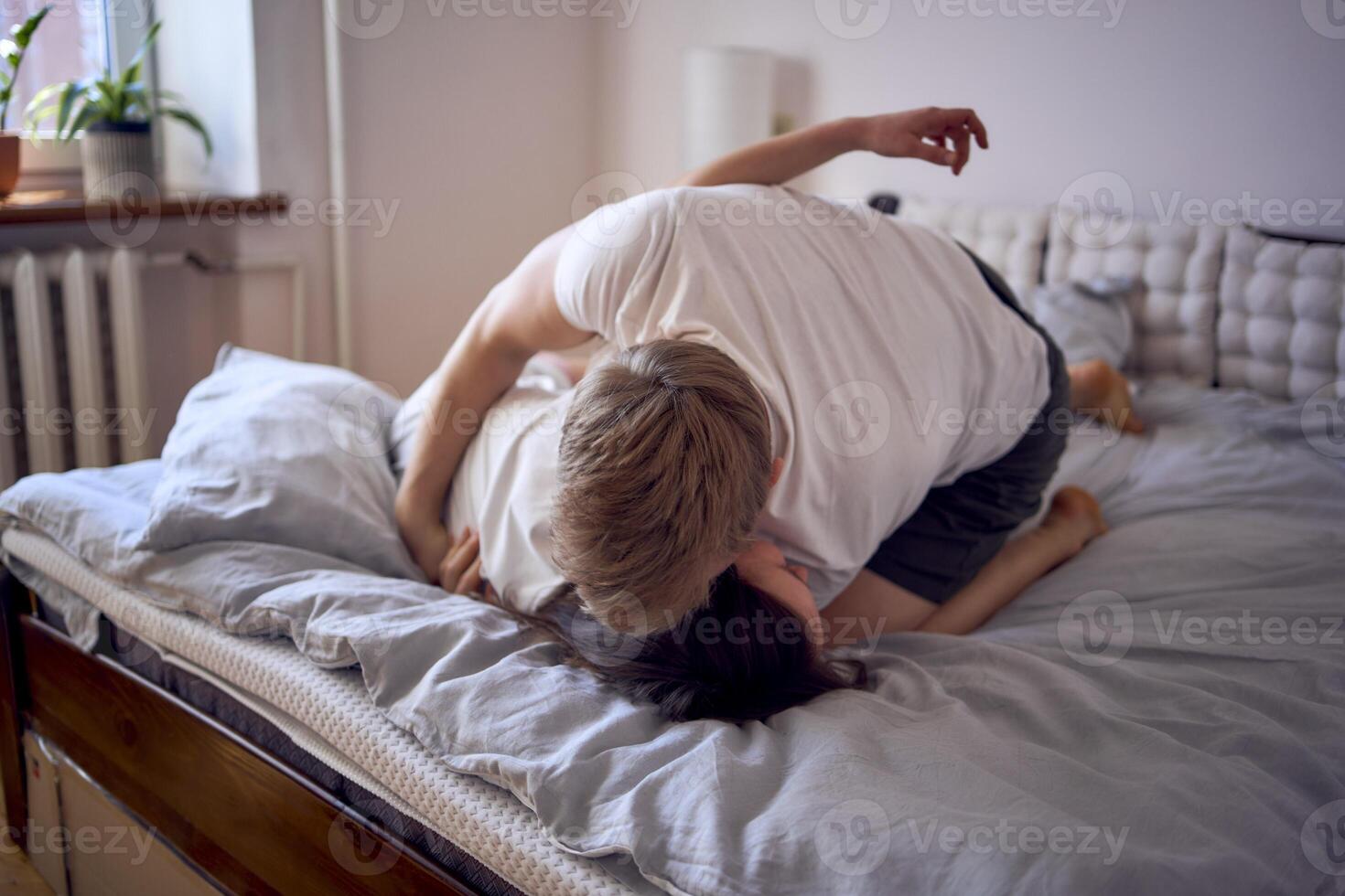 une Jeune magnifique couple en jouant et lutte sur le lit, minimalisme photo