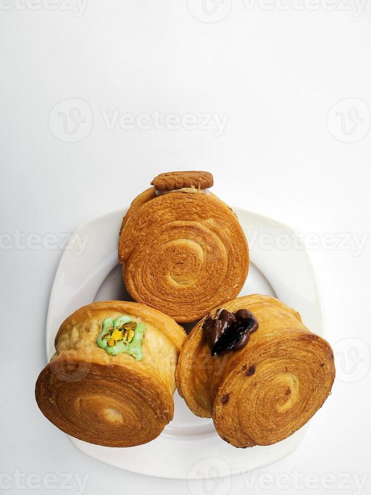 crombolonis, Nouveau york rouleau croissant avec une variété de sauce garnitures, servi sur une blanc assiette et isolé blanc Contexte. photo