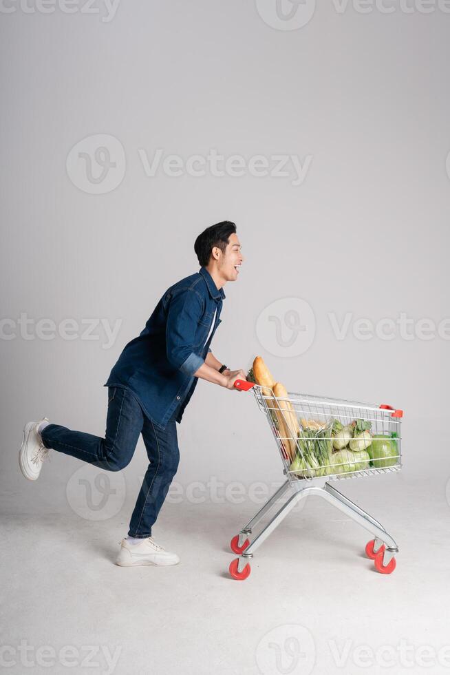 content souriant homme pousser supermarché Chariot isolé sur blanc Contexte photo