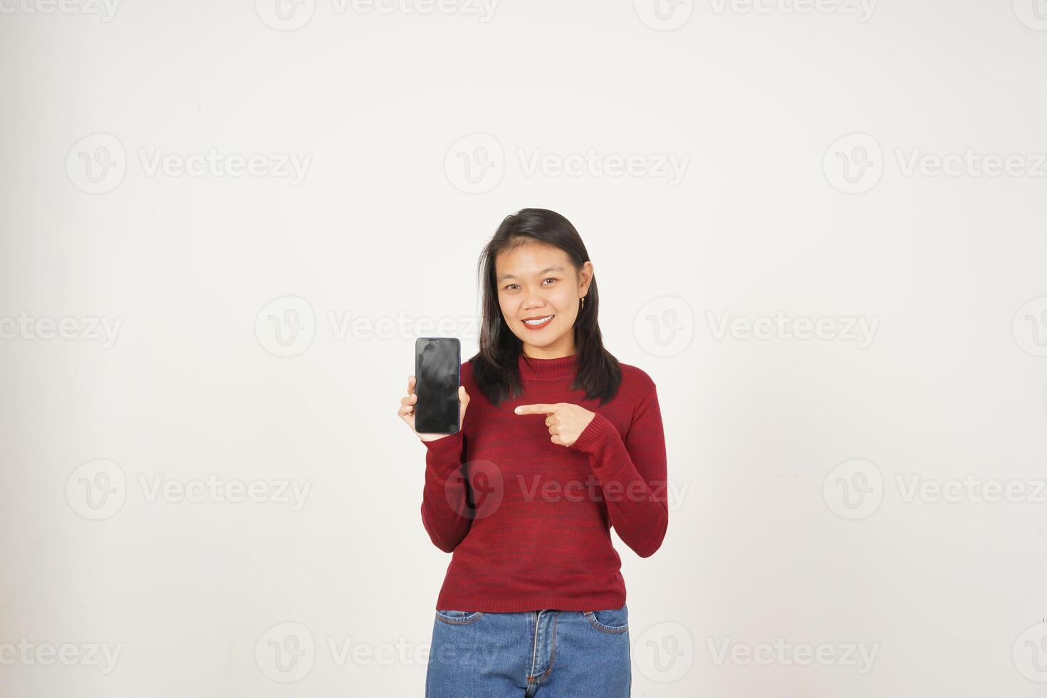 Jeune asiatique femme dans rouge T-shirt montrant et montrer du doigt téléphone intelligent Vide écran isolé sur blanc Contexte photo