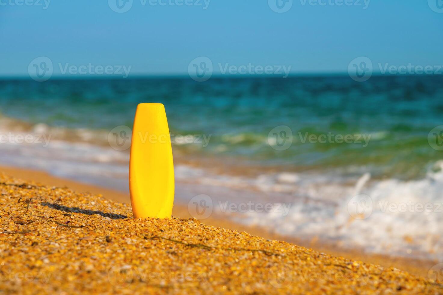 une bouteille de crème solaire sans pour autant une étiquette sur le plage sur une ensoleillé journée. Vide pour La publicité votre crème et Étiquettes photo