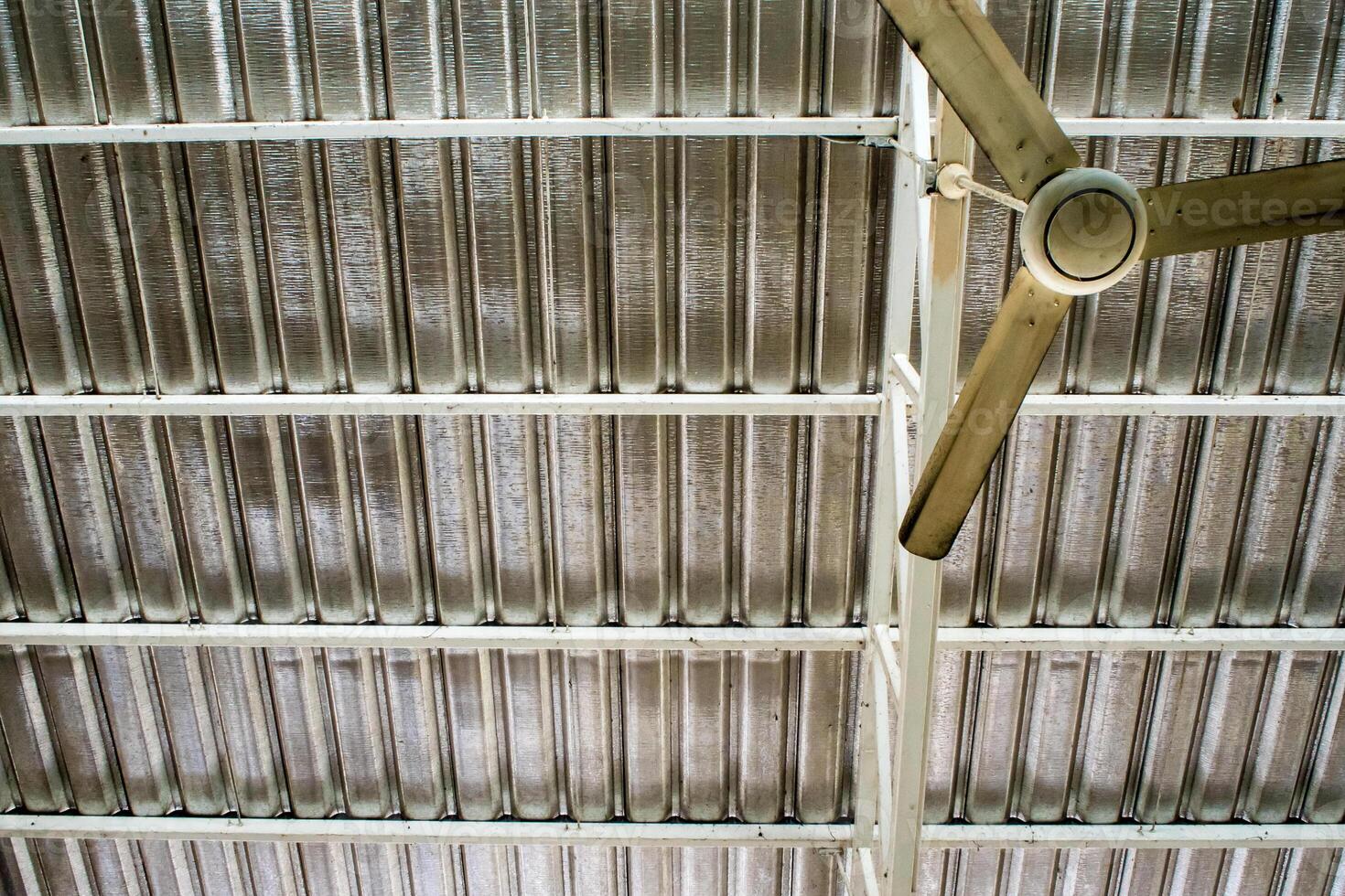 électrique plafond ventilateur en dessous de le métal feuille toit photo