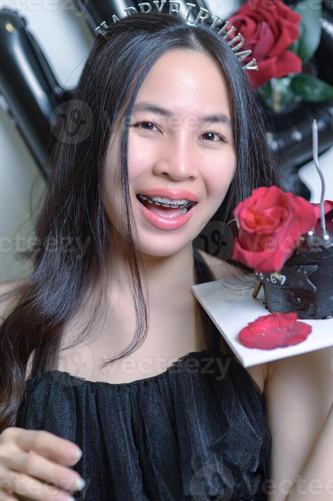 magnifique femme portant une noir robe et Chocolat gâteau dans le concept de anniversaire photo