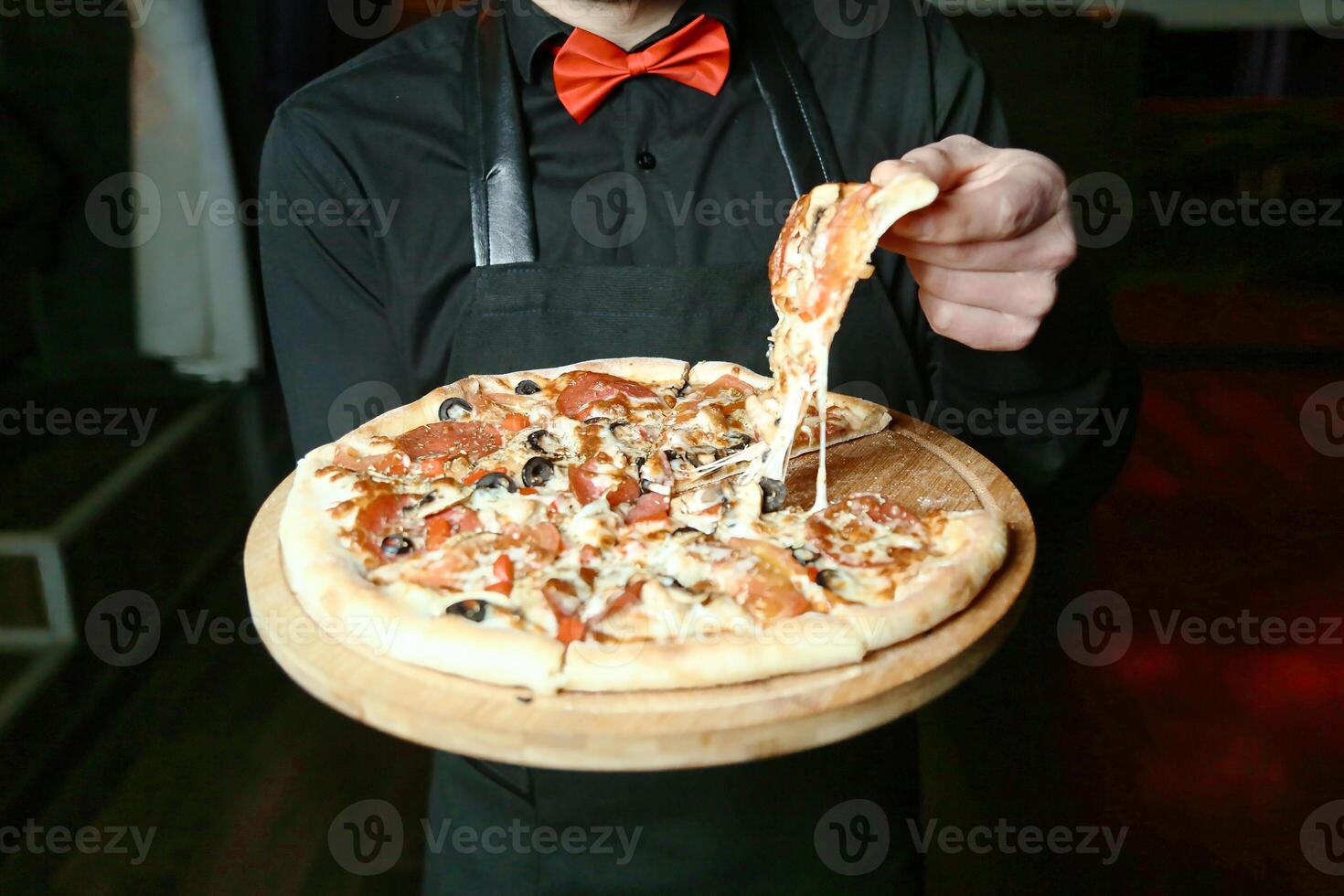 homme dans tablier en portant Pizza photo