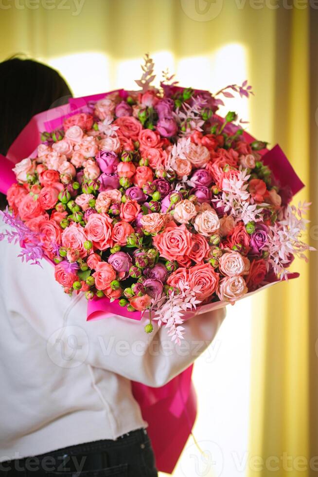 homme en portant grand bouquet de fleurs photo