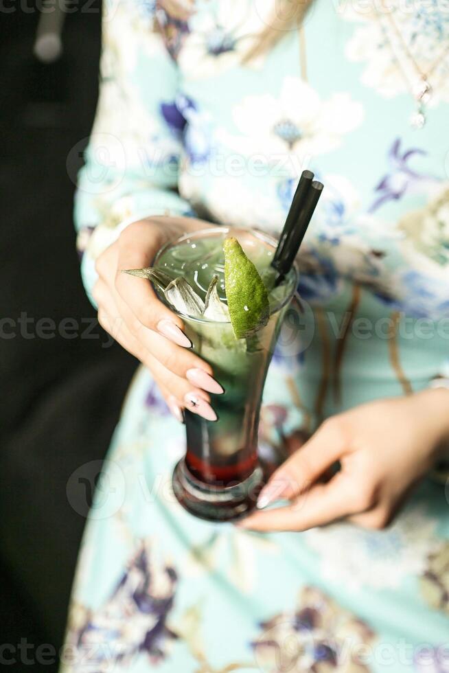 femme en portant une boisson à une jardin fête photo