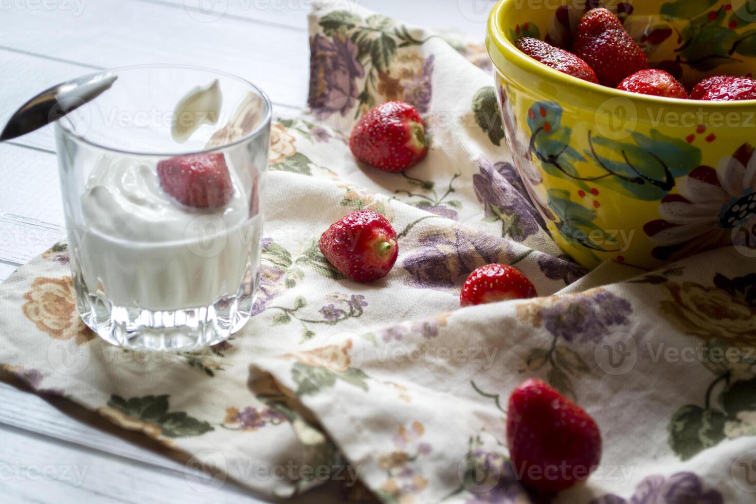 une agresser de mûr des fraises et verre de crème sur une blanc en bois tableau. le en bonne santé aliments. photo