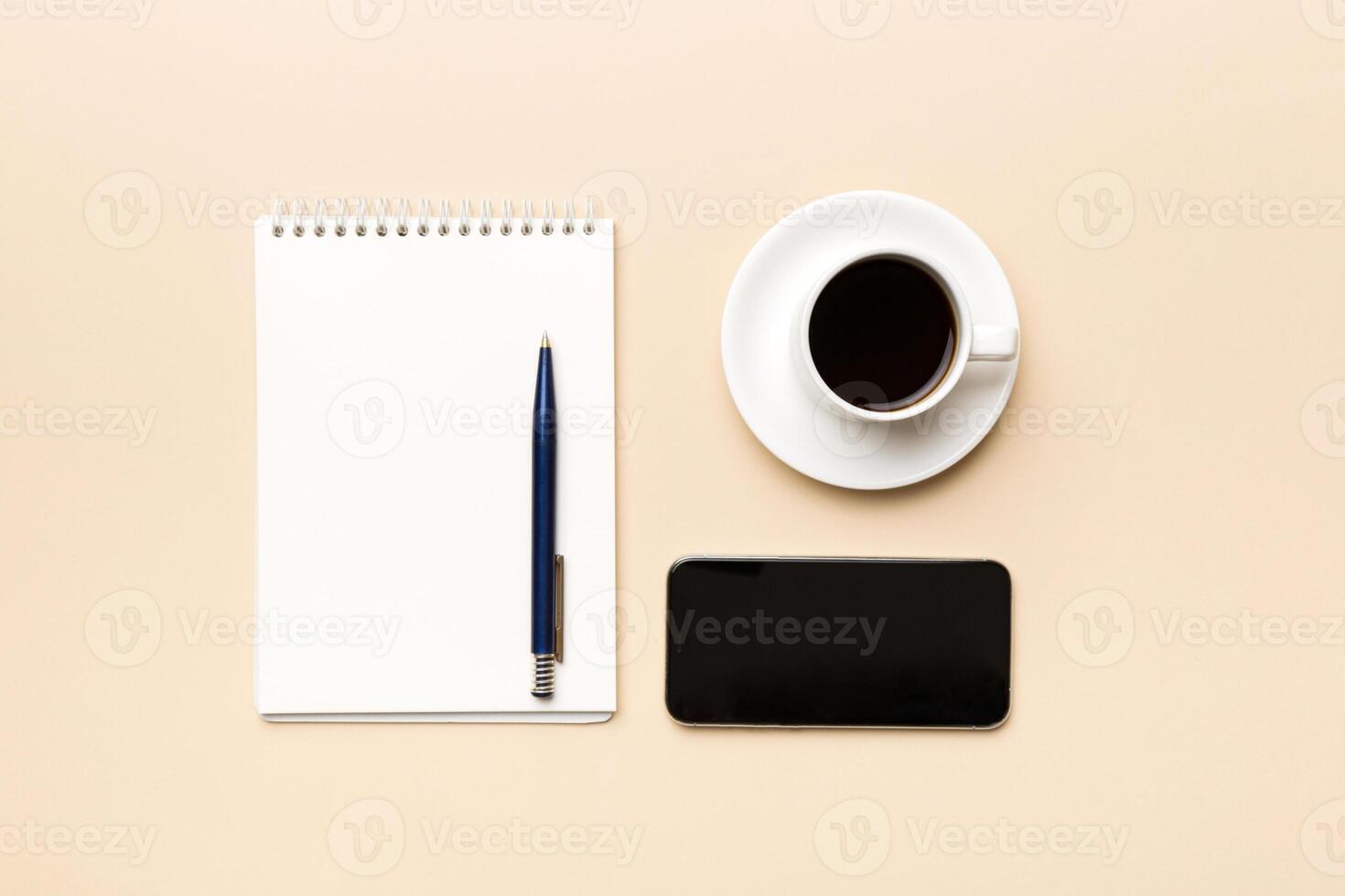 moderne Bureau bureau table avec carnet de notes, téléphone intelligent et autre Provisions avec tasse de café. Vide carnet page pour vous conception. Haut voir, plat allonger photo