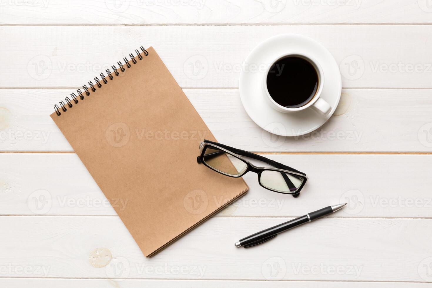 moderne Bureau bureau table avec carnet et autre Provisions avec tasse de café. Vide carnet page pour vous conception. Haut voir, plat allonger photo