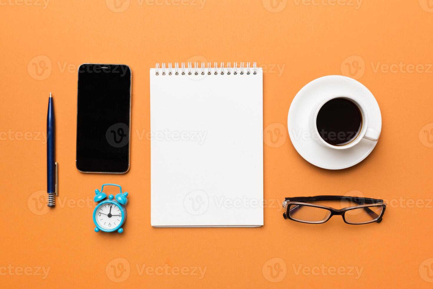 moderne Bureau bureau table avec carnet de notes, téléphone intelligent et autre Provisions avec tasse de café. Vide carnet page pour vous conception. Haut voir, plat allonger photo