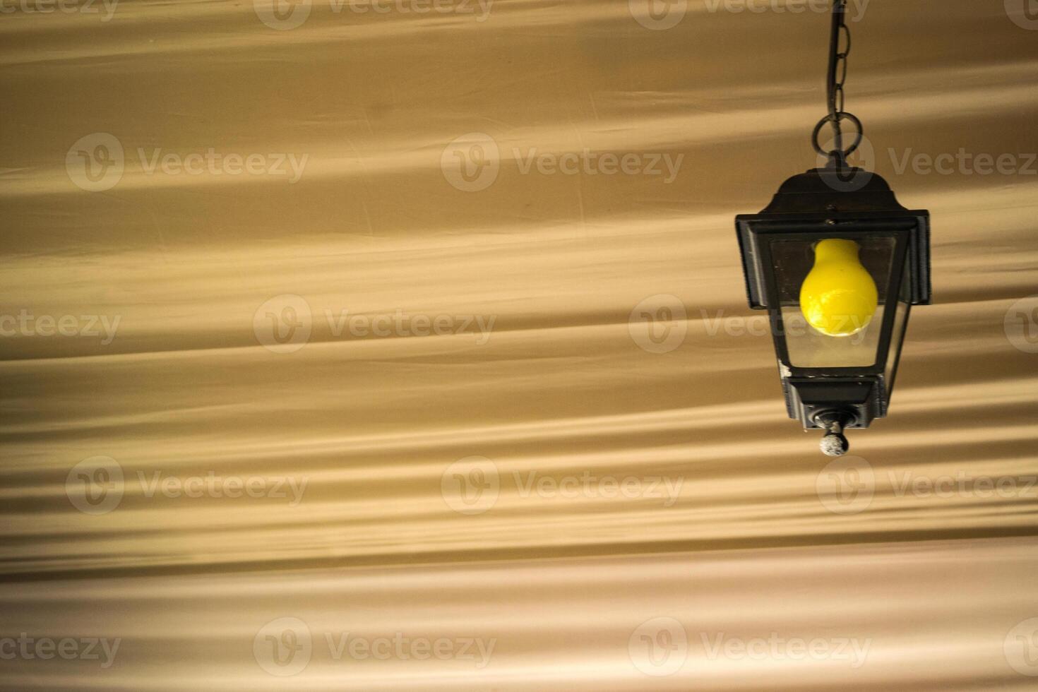 le Jaune ampoule dans le noir lanterne sur le plafond. proche en haut. photo